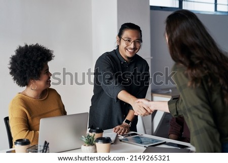 Its been a pleasure doing business with you. Cropped shot of a group of young businesspeople greeting each other with a handshake before sitting down in the office. Royalty-Free Stock Photo #2149265321