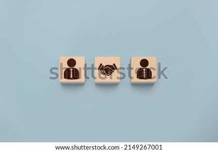 business contract. Hand putting hand shaking which print screen on wooden cube block in front of human icon for business deal and agreement concept. Teamwork process of partner and best relationship. Royalty-Free Stock Photo #2149267001