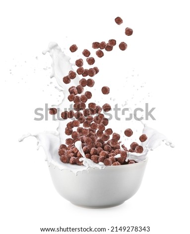 Pouring of tasty chocolate corn balls into bowl with milk splashes on white background Royalty-Free Stock Photo #2149278343