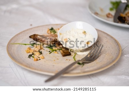 The leftover food and dirty dishes on the restaurant table. Scraps left over after the party. Royalty-Free Stock Photo #2149285115