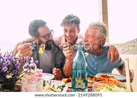 Father grandfather and son eaing together having fun. father's day concept celebration with men family enjoying meal on the table. Cheerful man young adult and mature laughing and having lunch Royalty-Free Stock Photo #2149288095
