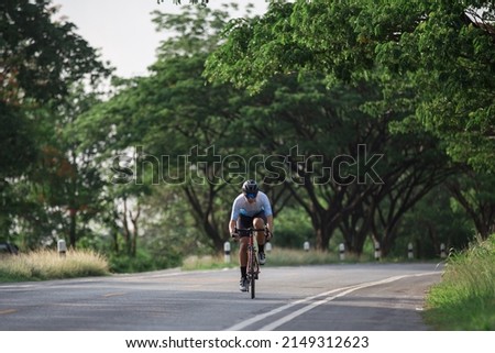 Cyclist pedaling on a racing bike outdoors in sun set .The image of cyclist in motion on the background in the evening. Royalty-Free Stock Photo #2149312623