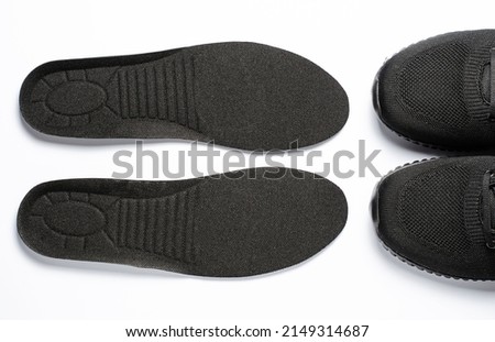 Orthopedic insoles and sports sneakers. White background. The concept of prevention of foot diseases
