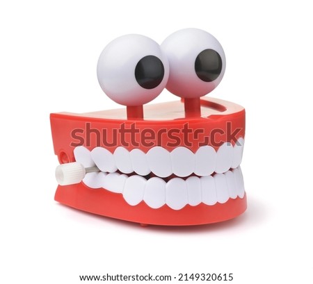 Funny toy clockwork jumping teeth with eyes isolated on white
