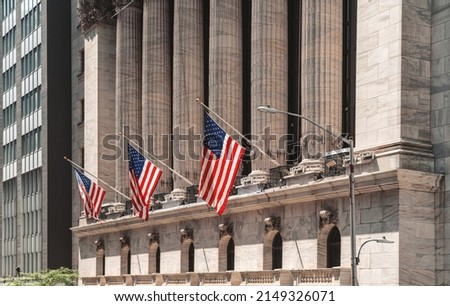 New York wall street, stock exchange building and three american flags in row. Summer time and daylight. Concept of money and banking