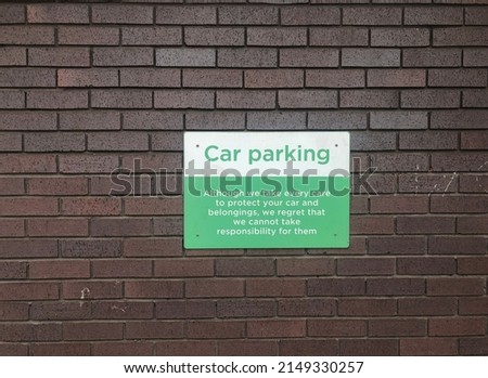 green and white car parking sign on a dark brick background