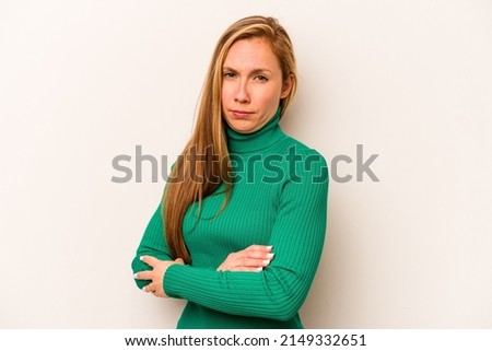 Young caucasian woman isolated on white background suspicious, uncertain, examining you.