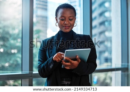 Making new connections at a tap of a finger. Shot of a young businesswoman using a digital tablet at work. Royalty-Free Stock Photo #2149334713