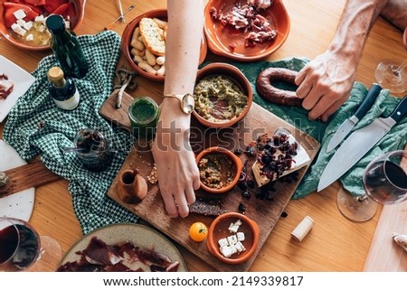 top view of table diner with tapas food - friends people eating and grabbing appetizer sitting around together Royalty-Free Stock Photo #2149339817