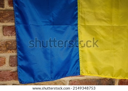 Flag of Ukraine, a great national symbol on a brick background. Big yellow and blue Ukrainian state flag Independence Constitution Day, National holiday. Royalty-Free Stock Photo #2149348753
