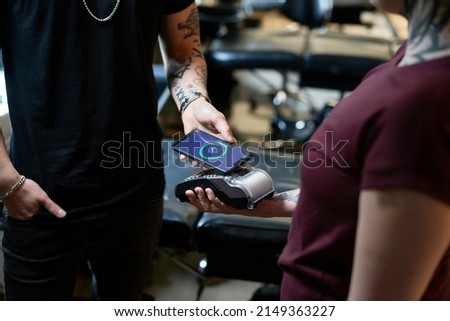 Close up of caucasian woman taking a pay in tattoo studio