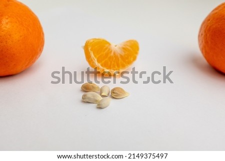 Two orange and one slice with five seeds on a white background, side view. Ripe orange composition for publication, poster, calendar, post, screensaver, banner, cover, website, space for your design