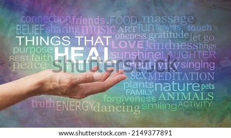 Wall Art Words associated with THINGS THAT HEAL - female hand surrounded by a healing words tag cloud against  a rustic background with rainbow colours  ideal for a Healers Therapy Room wall 
 Royalty-Free Stock Photo #2149377891