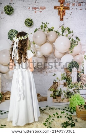 
Hands of the First Communion girl praying under the cross of Saint Francis. First Holy Communion. A girl in a white communion dress after receiving her First Holy Communion  Royalty-Free Stock Photo #2149393381