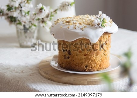 Traditional easter cake or sweet bread, apple brahces in bloom on white plate on light linen tablecloth. Side view, selective focus. Easter treat, holiday symbol