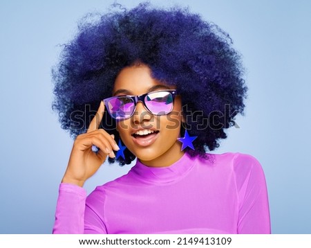 Beauty portrait of African American girl in colored holographic sunglasses. Beautiful black woman on blue background. Cosmetics, makeup and fashion Royalty-Free Stock Photo #2149413109