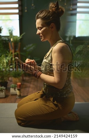 modern 40 years old housewife in the modern green living room using smartphone.