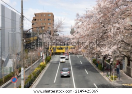 Blurred scene of Japanese road during spring with pink cherry blossom (Sakura) along the street
