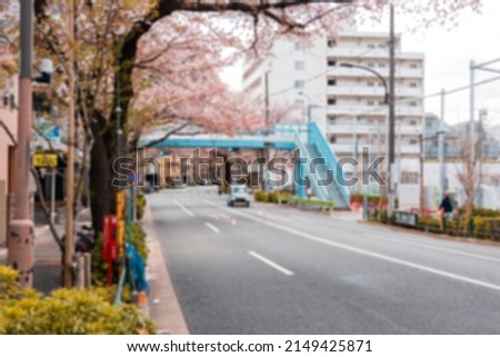 Blurred scene of Japanese road during spring with pink cherry blossom (Sakura) along the street