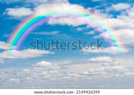 beautiful sky with colorful rainbow. Stunning blue sky panoramic rainbow big fluffy clouds with a giant arcing rainbow against beautiful summer time blue sky with copy space for messages or text