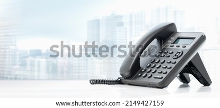 telephone with VOIP on white table on blurred city background. customer service support, call center concept. telephone devices at office desk. Modern VoIP or IP phone. Royalty-Free Stock Photo #2149427159