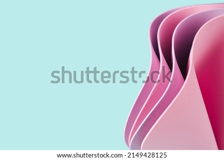 Wavy 3D pink sheets on a bright mint background. Summer abstract template.