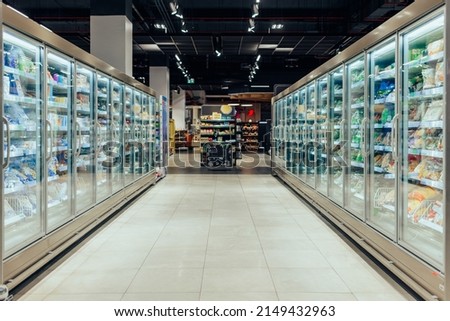 Empty supermarket aisle with freezers showcases with different products