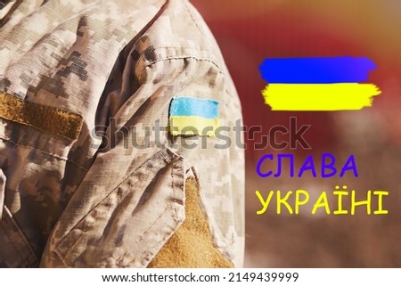 Ukrainian flag on military uniform. Ukrainian slogan - Glory to Ukraine. Stop Russian aggression. Stop the war in Ukraine. Stay with Ukraine. Sensation. Pray for Ukraine. Copy space.