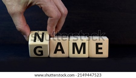 Name of the game symbol. Wooden blocks with concept words Name Game. Businessman hand. Beautiful grey table grey background. Business and name of the game concept. Copy space.