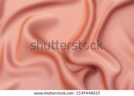 Close-up texture of natural red or pink fabric or cloth in same color. Fabric texture of natural cotton, silk or wool, or linen textile material. Red and orange canvas background. Royalty-Free Stock Photo #2149448023
