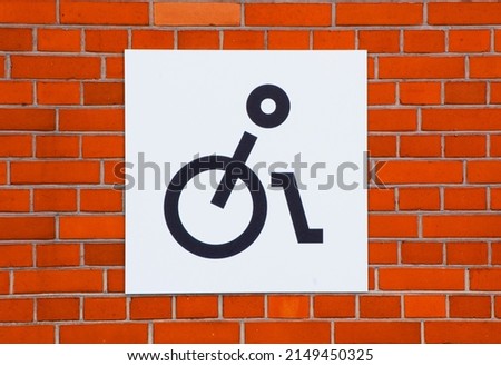 Disability car parking sign on the brick wall.