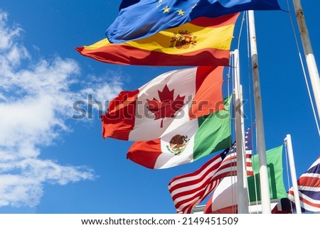 Flags of Canada, Spain, Mexico, the European Union, the USA are developing against the sky. Flags of different countries on flagpoles, the concept of negotiations and international relations. Royalty-Free Stock Photo #2149451509