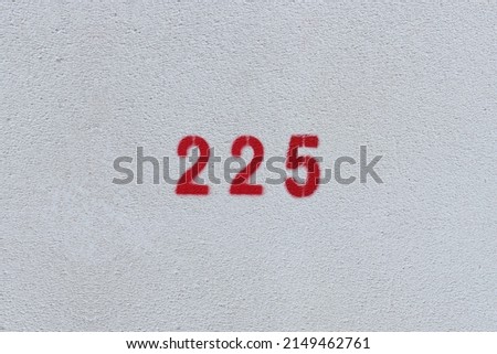 RED Number 225 on the white wall. Spray paint.two hundred and twenty fivetwo hundred and twenty five
