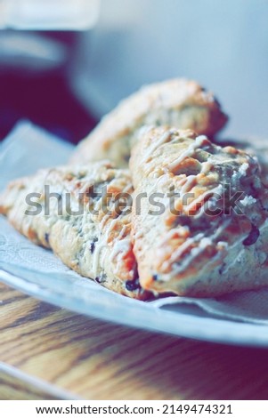 blueberry scones served in a white plate on a wooden table, pictured in modern tones.