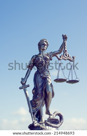 image of themis sculpture, femida or justice goddess on bright blue sky sunny outdoors background