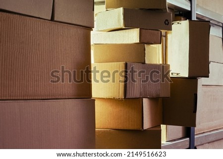 Warehouse overflowing with boxes of goods and postal parcels. Cardboard boxes on the shelves of a full stocked warehouse