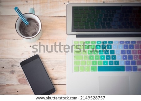Top vertical view of desk with phone coffee and laptop. Work place on wooden table at office. Home and business online concept. Smart working and connection. Modern lifestyle job