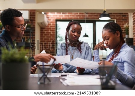 African american business people discussing financial strategy while in workspace. Company office employees cooperating regarding startup project marketing expenses while in modern office interior. Royalty-Free Stock Photo #2149531089