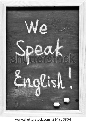 We Speak English! written with Chalk on Blackboard