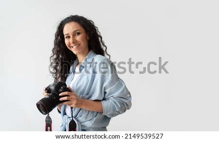 Professional Photographer Woman Holding Photo Camera Posing Smiling To Camera Standing Over White Wall Background. Lady Taking Photos Posing With Photocamera. Photography. Free Space For Text