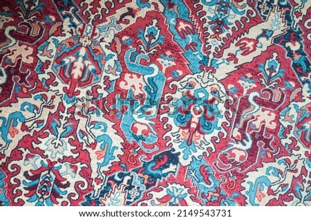 Oriental woolen carpet with traditional colorful floral ornament. Close up photo background
