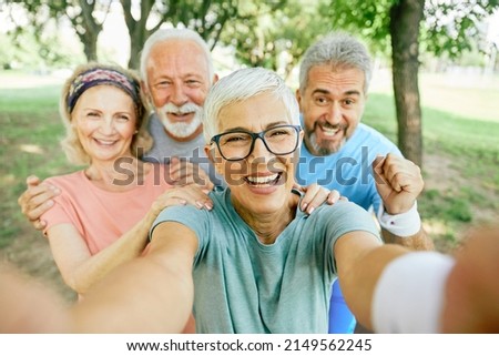 Smiling active senior people posing and taking selfie together in the park Royalty-Free Stock Photo #2149562245