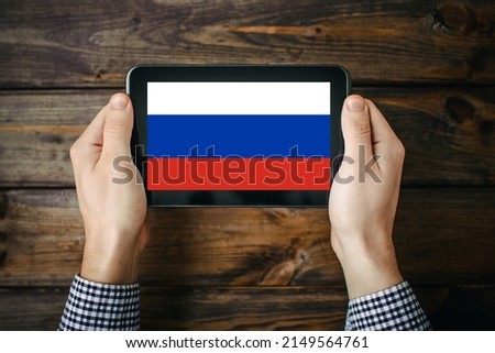 Russian flag on tablet screen. Technology search background. Searching information about enemy at war. Stop the war background. Anonymous hackers revealing information. War news site.