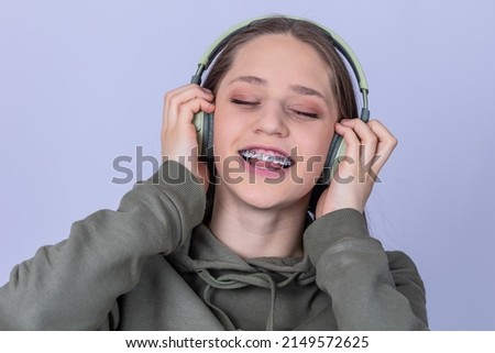 Close up girl portrait with headphones singing with closed eyes