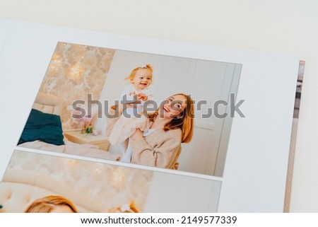 page with mother and daughter. a Photobook of family at home on a white background. Photobook is gift. professional photographer and designer. printing of photos and journals in photo laboratory