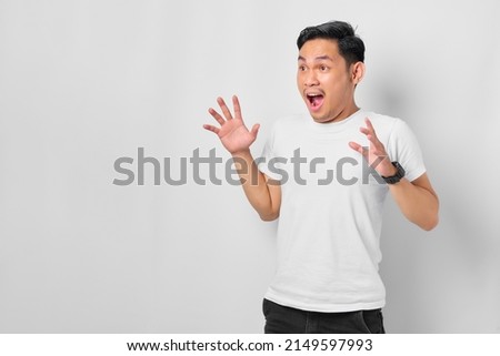 Shocked young Asian man looking away with opened mouth isolated on white background Royalty-Free Stock Photo #2149597993