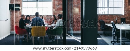 Team of businesspeople having a discussion during a meeting. Group of creative businesspeople attending their morning briefing in an office. Businesspeople working together as a team. Royalty-Free Stock Photo #2149599669