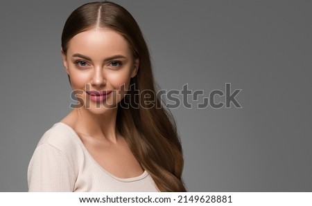 Beautiful woman portrait with curly long healthy. Hair beauty natural casual style Gray background