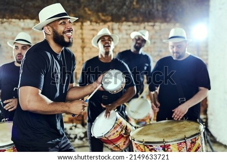 Feeling the rhythm in the drums. Shot of a group of musical performers playing together indoors. Royalty-Free Stock Photo #2149633721