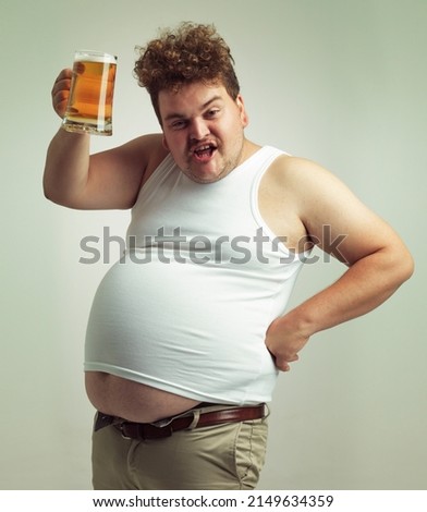 Cheers. Shot of an overweight man raising his beer in toast. Royalty-Free Stock Photo #2149634359